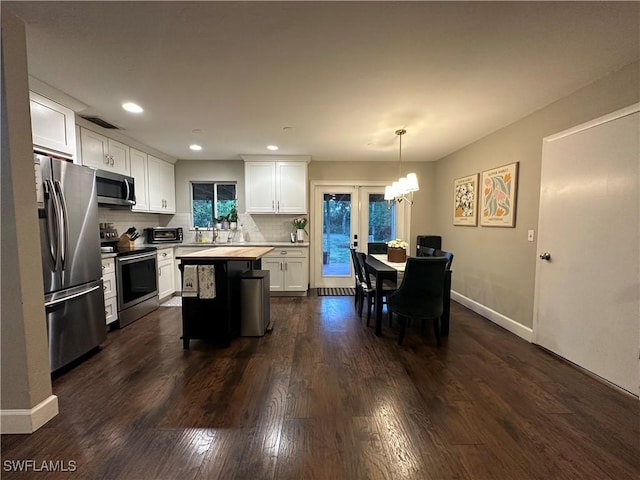 kitchen featuring tasteful backsplash, dark wood-style floors, white cabinetry, light countertops, and stainless steel appliances