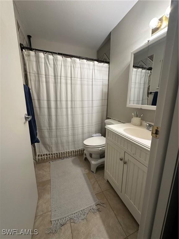 full bathroom featuring tile patterned flooring, vanity, a shower with curtain, and toilet