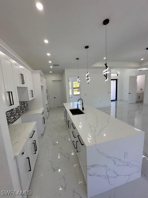 kitchen featuring marble finish floor, a sink, and recessed lighting
