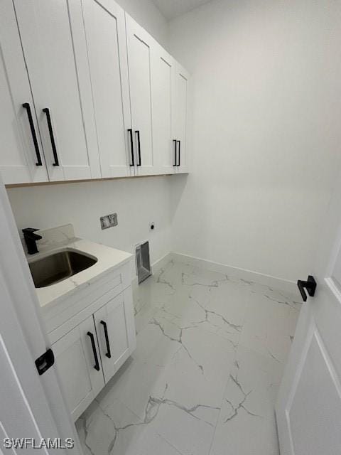 laundry area with a sink, hookup for an electric dryer, marble finish floor, cabinet space, and baseboards