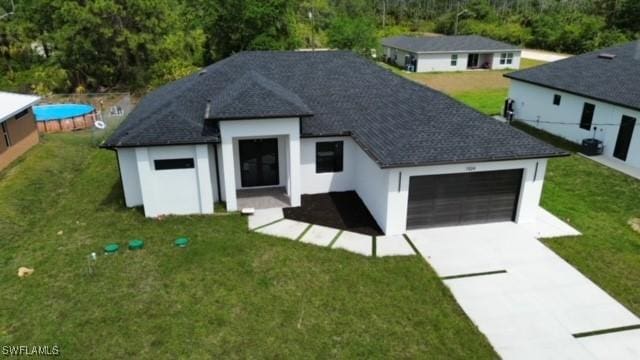 exterior space featuring concrete driveway, a front yard, and a garage