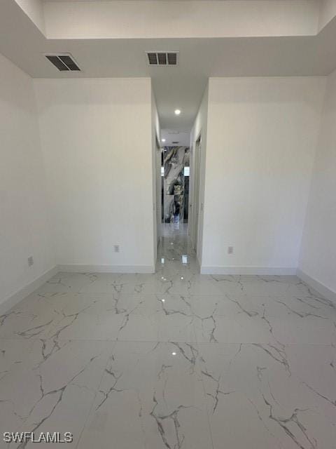 empty room featuring visible vents, marble finish floor, and baseboards