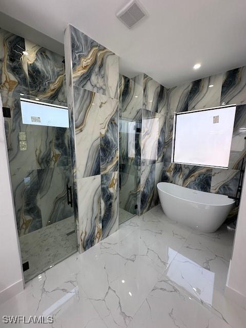 full bath with a marble finish shower, stone wall, marble finish floor, a soaking tub, and visible vents