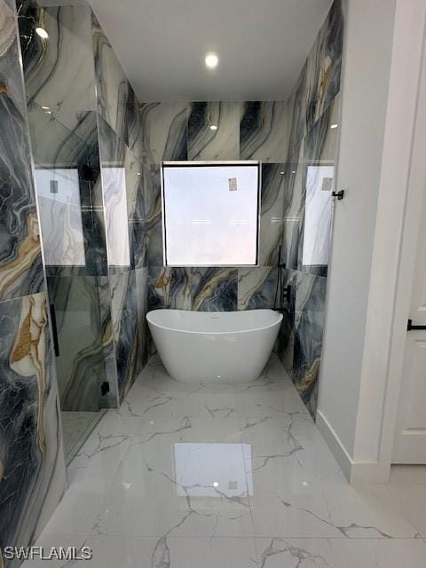 bathroom featuring a soaking tub, marble finish floor, recessed lighting, and a marble finish shower