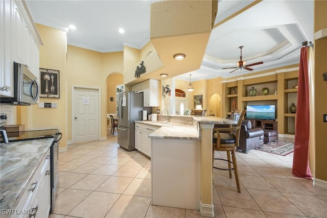 18510 Ellen Ave, Port Charlotte, FL 33948 - kitchen featuring ornamental molding, a peninsula, a breakfast bar area, stainless steel appliances, and arched walkways