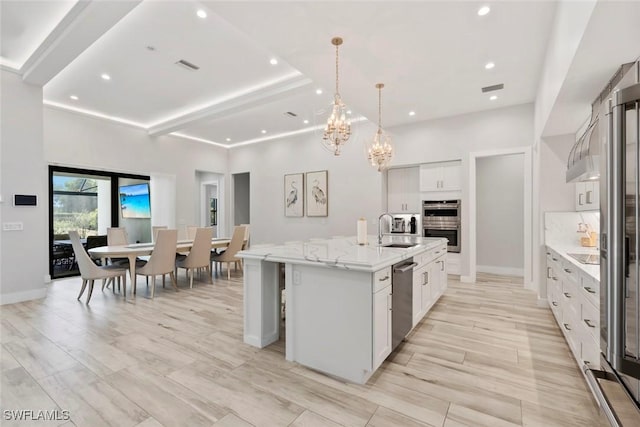 9974 Winterview Dr, Naples, FL 34109 - kitchen with a sink, stainless steel appliances, recessed lighting, a center island with sink, and white cabinets