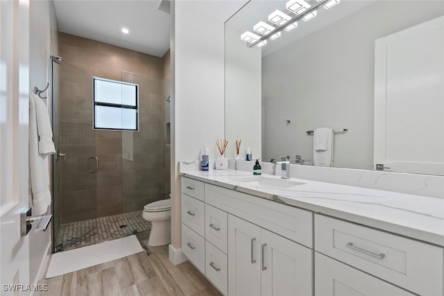 9974 Winterview Dr, Naples, FL 34109 - bathroom featuring vanity, toilet, a stall shower, wood finished floors, and recessed lighting