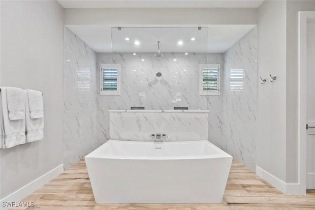9974 Winterview Dr, Naples, FL 34109 - full bathroom featuring a freestanding tub, plenty of natural light, wood finished floors, recessed lighting, and baseboards
