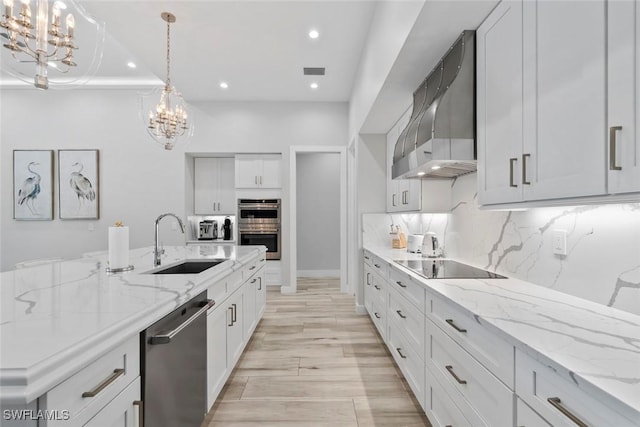 9974 Winterview Dr, Naples, FL 34109 - kitchen with appliances with stainless steel finishes, wall chimney exhaust hood, a chandelier, a sink, and recessed lighting