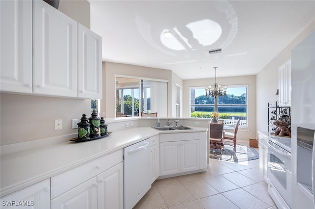 4660 Winged Foot Ct Unit 102, Naples, FL 34112 - kitchen with a peninsula, a healthy amount of sunlight, a sink, and white appliances