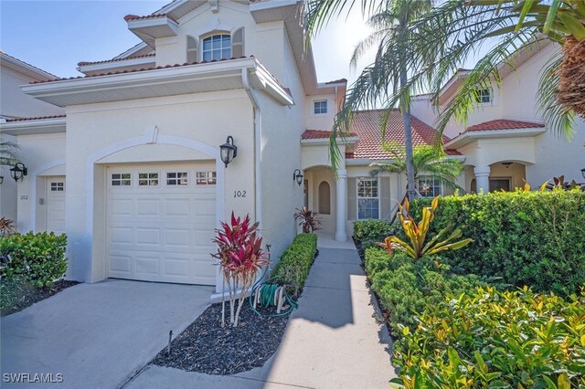4660 Winged Foot Ct Unit 102, Naples, FL 34112 - mediterranean / spanish-style house featuring a garage, stucco siding, concrete driveway, and a tile roof