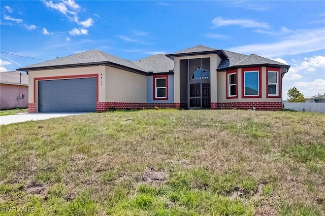 4911 Bywood St, Lehigh Acres, FL 33971 - view of front of property featuring brick siding, a garage, driveway, and a front lawn