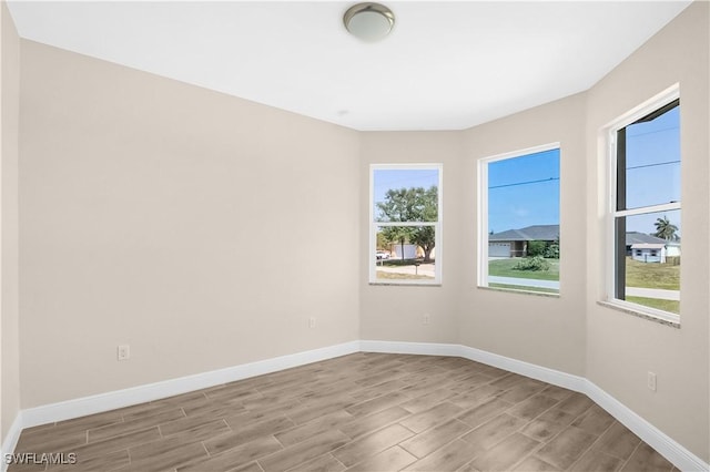 4911 Bywood St, Lehigh Acres, FL 33971 - empty room featuring wood tiled floors, plenty of natural light, and baseboards