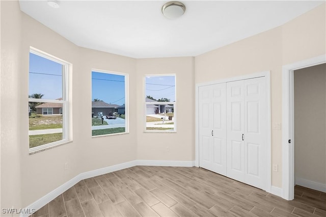 4911 Bywood St, Lehigh Acres, FL 33971 - unfurnished bedroom featuring multiple windows, wood finished floors, and baseboards