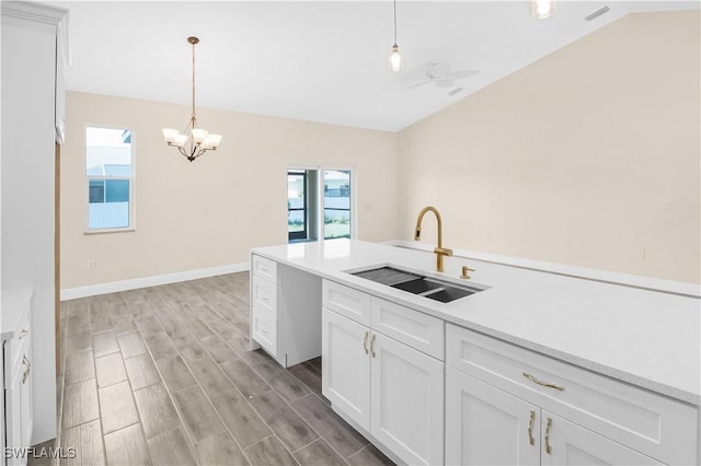 4911 Bywood St, Lehigh Acres, FL 33971 - kitchen with a sink, vaulted ceiling, healthy amount of natural light, white cabinets, and light wood finished floors