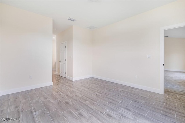 4909 Berryman St, Lehigh Acres, FL 33971 - spare room with baseboards, wood finished floors, and visible vents