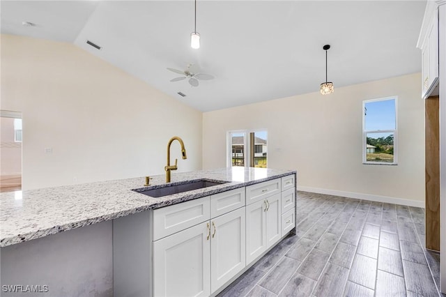 4909 Berryman St, Lehigh Acres, FL 33971 - kitchen featuring white cabinets, lofted ceiling, a healthy amount of sunlight, a sink, and ceiling fan