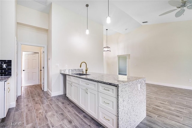 4909 Berryman St, Lehigh Acres, FL 33971 - kitchen featuring a peninsula, a sink, light wood-type flooring, white cabinetry, and ceiling fan