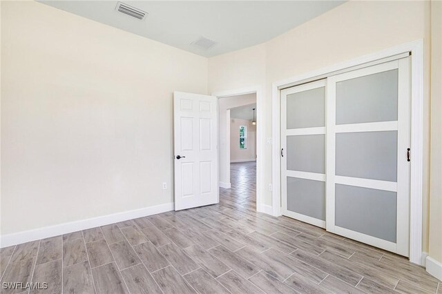 4909 Berryman St, Lehigh Acres, FL 33971 - unfurnished room with baseboards, wood finished floors, and visible vents