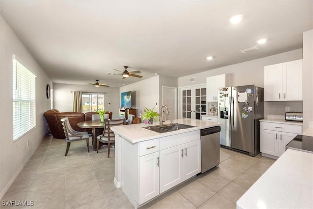 8813 Swell Brooks Ct, North Fort Myers, FL 33917 - kitchen with appliances with stainless steel finishes, white cabinets, light tile patterned flooring, a center island with sink, and ceiling fan