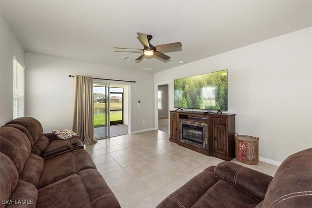 8813 Swell Brooks Ct, North Fort Myers, FL 33917 - living room featuring a ceiling fan, light tile patterned flooring, and a glass covered fireplace