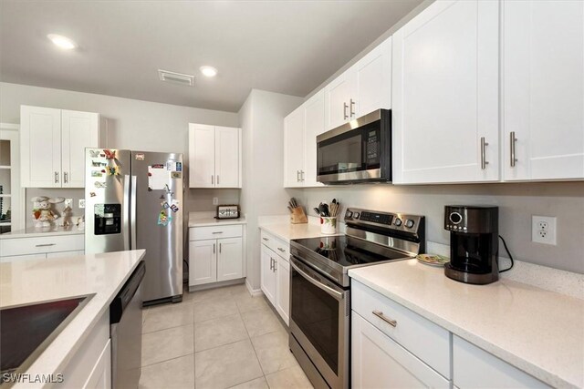 8813 Swell Brooks Ct, North Fort Myers, FL 33917 - kitchen with stainless steel appliances, light countertops, white cabinetry, and recessed lighting