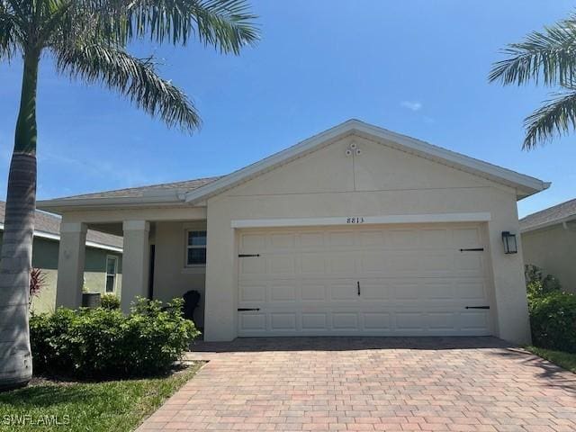 8813 Swell Brooks Ct, North Fort Myers, FL 33917 - ranch-style home featuring stucco siding, decorative driveway, and a garage
