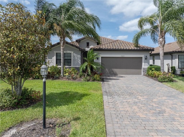 19874 Beverly Park Rd, Estero, FL 33928 - mediterranean / spanish-style house featuring a garage, a front lawn, decorative driveway, stucco siding, and a tiled roof