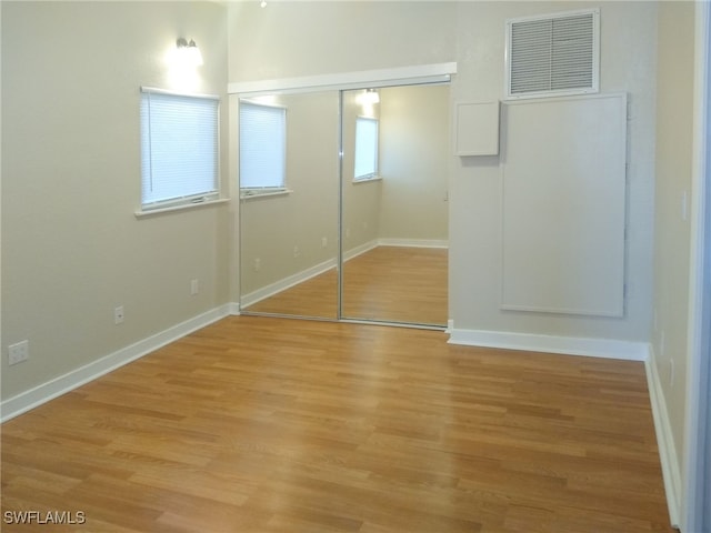 unfurnished bedroom featuring a closet, visible vents, light wood-type flooring, and baseboards