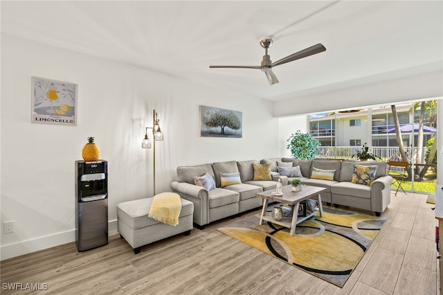 living room featuring baseboards, wood finished floors, and a ceiling fan