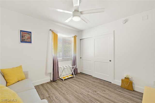living area with light wood finished floors, baseboards, and ceiling fan