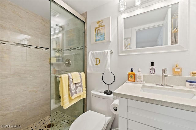 bathroom with a shower stall, vanity, and toilet