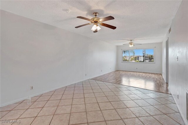 unfurnished room with a ceiling fan, a textured ceiling, visible vents, and light tile patterned floors