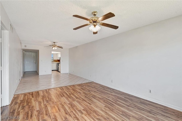 unfurnished living room with visible vents, baseboards, light wood-type flooring, a textured ceiling, and a ceiling fan