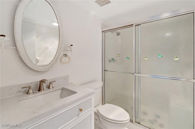 bathroom featuring visible vents, a stall shower, toilet, and vanity