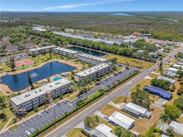 birds eye view of property with a water view and a wooded view