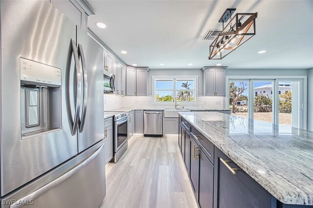446 Lake Murex Cir, Sanibel, FL 33957 - kitchen with light wood-style floors, a sink, backsplash, and stainless steel appliances