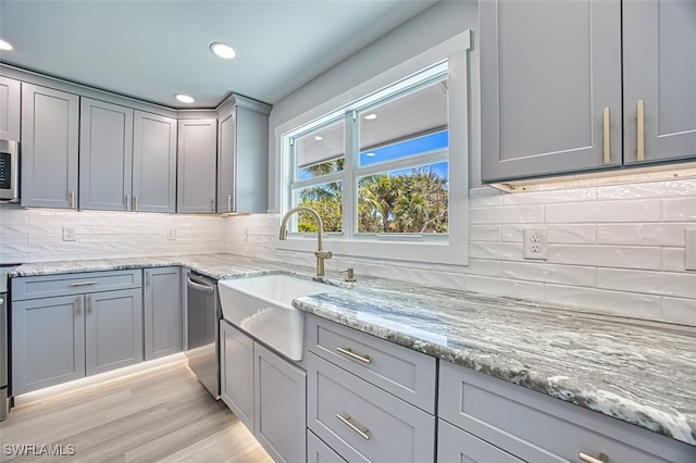 446 Lake Murex Cir, Sanibel, FL 33957 - kitchen featuring a sink, tasteful backsplash, gray cabinetry, and stainless steel appliances