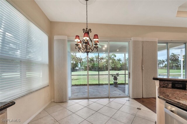 317 Harvard Ln, Naples, FL 34104 - unfurnished dining area with light tile patterned floors, a chandelier, and healthy amount of natural light