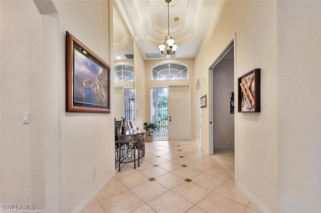 317 Harvard Ln, Naples, FL 34104 - foyer with a chandelier, a tray ceiling, baseboards, light tile patterned flooring, and crown molding
