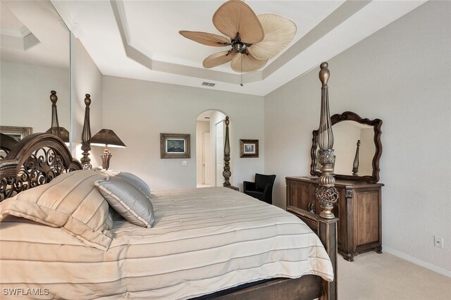 317 Harvard Ln, Naples, FL 34104 - bedroom with a tray ceiling, light colored carpet, arched walkways, ceiling fan, and baseboards