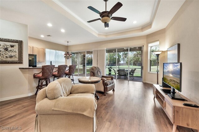 317 Harvard Ln, Naples, FL 34104 - living room featuring a raised ceiling, healthy amount of natural light, wood finished floors, recessed lighting, and ornamental molding