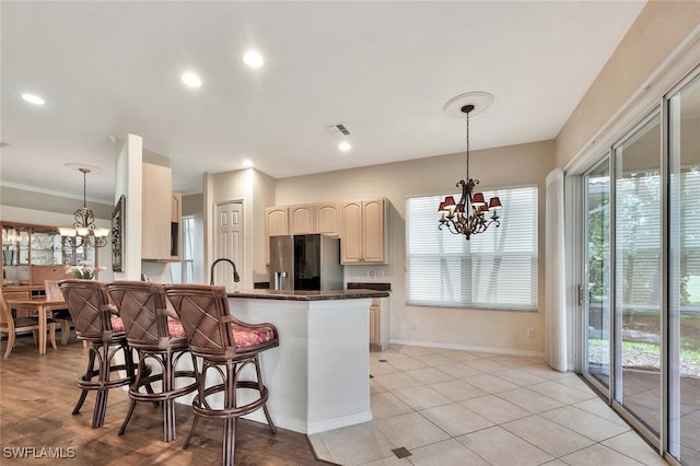 317 Harvard Ln, Naples, FL 34104 - kitchen with stainless steel fridge with ice dispenser, a chandelier, a breakfast bar, dark countertops, and recessed lighting