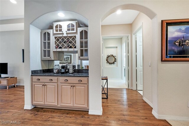 317 Harvard Ln, Naples, FL 34104 - kitchen with dark wood finished floors, arched walkways, glass insert cabinets, baseboards, and a textured wall