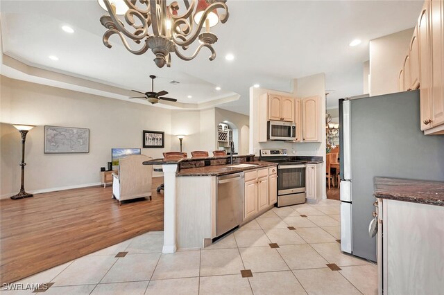 317 Harvard Ln, Naples, FL 34104 - kitchen with stainless steel appliances, ceiling fan, a sink, light tile patterned flooring, and a tray ceiling