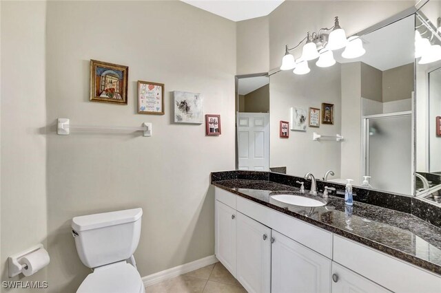 full bath with tile patterned floors, toilet, vanity, baseboards, and a stall shower