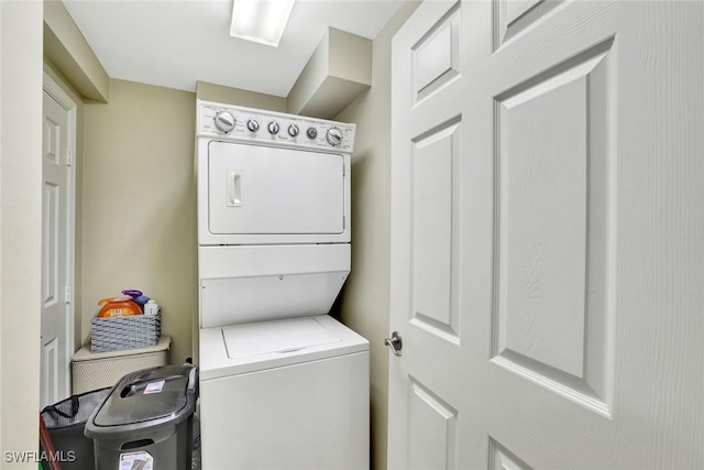 washroom with stacked washer and clothes dryer and laundry area