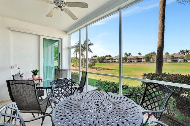 sunroom / solarium featuring a residential view and ceiling fan