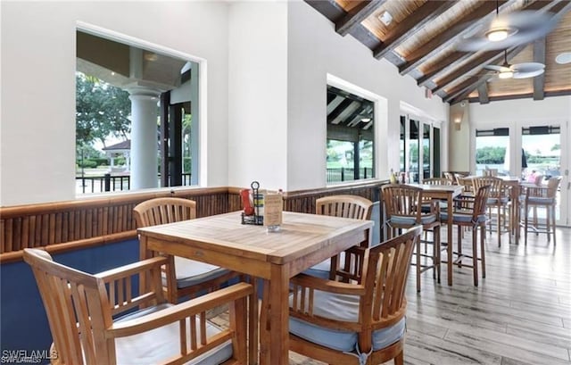 dining area with lofted ceiling with beams, plenty of natural light, a ceiling fan, and wood finished floors
