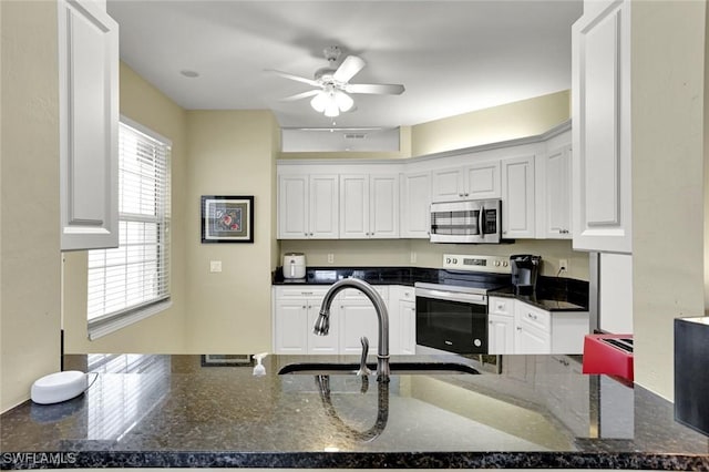 kitchen featuring stainless steel appliances, a peninsula, white cabinetry, and a ceiling fan
